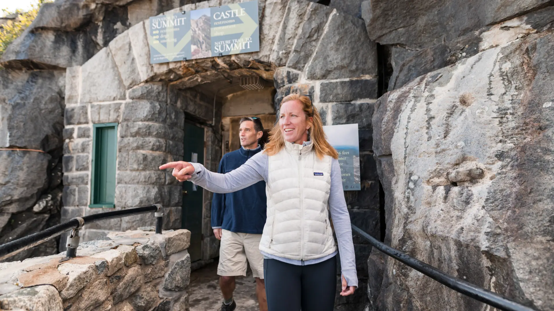 A man and woman explore a stone building on top of Whiteface.