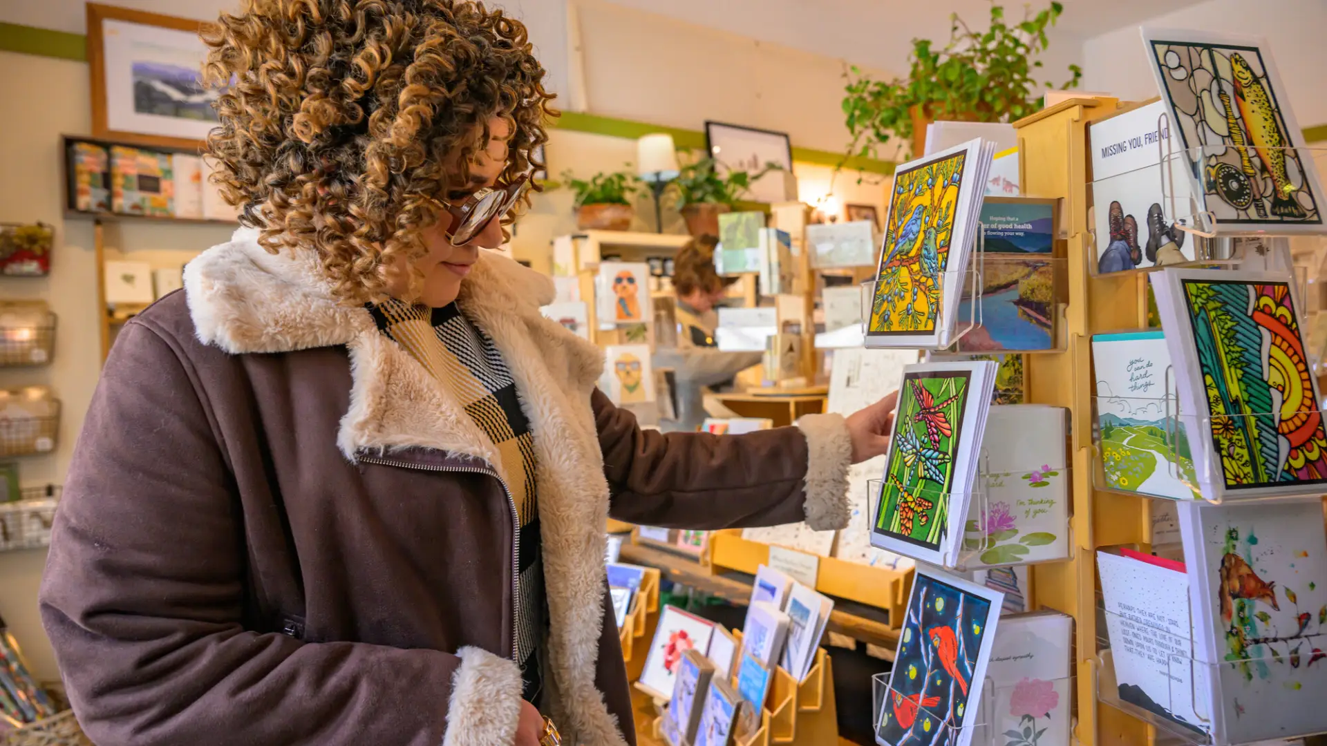 Woman looks at a card in a store in Lake Placid