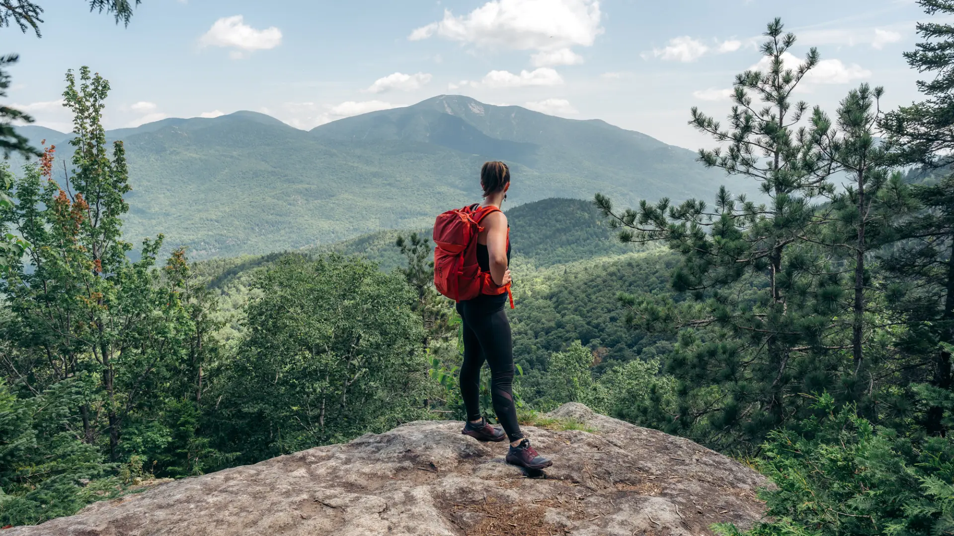 Hiker takes in the view from overlook near Rooster Comb summit