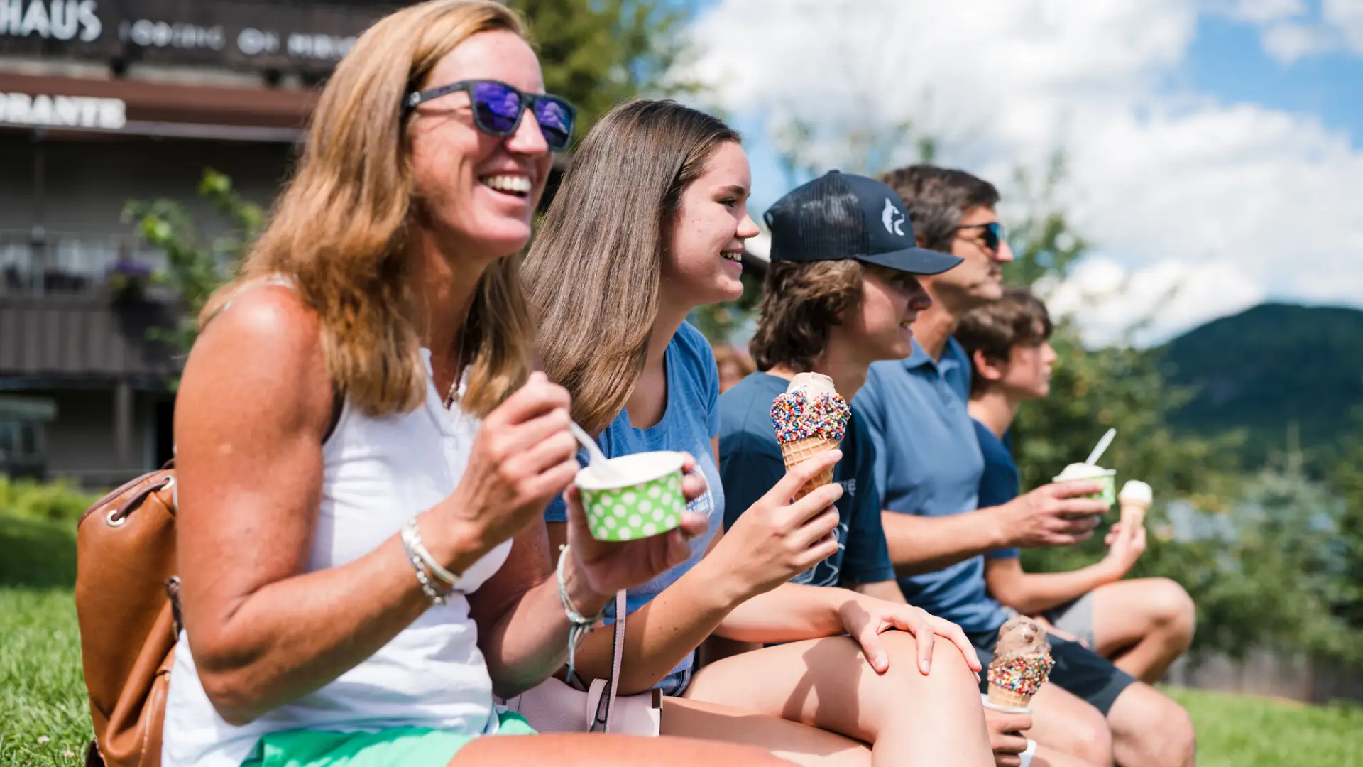 A family eating ice cream on a bench.