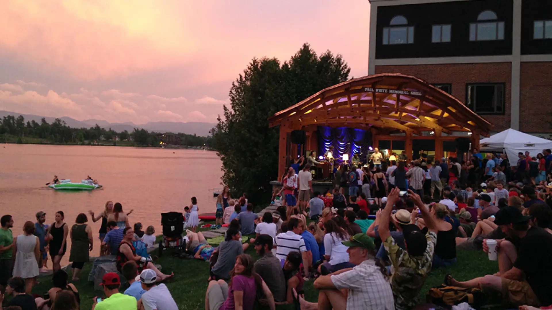 Sunset over Mirror Lake as crowd watchings a live music performance from Mid's Park