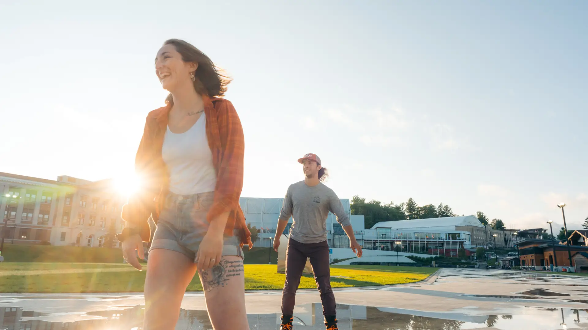 A woman and a man in-line skate on an outdoor, paved path on a sunny day.