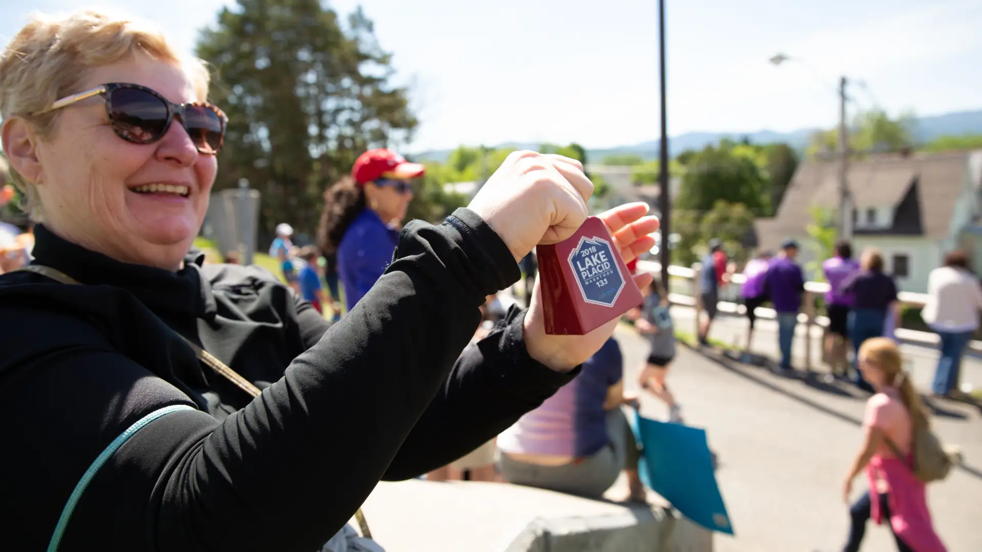 Fan rings a cowbell as athletes run by