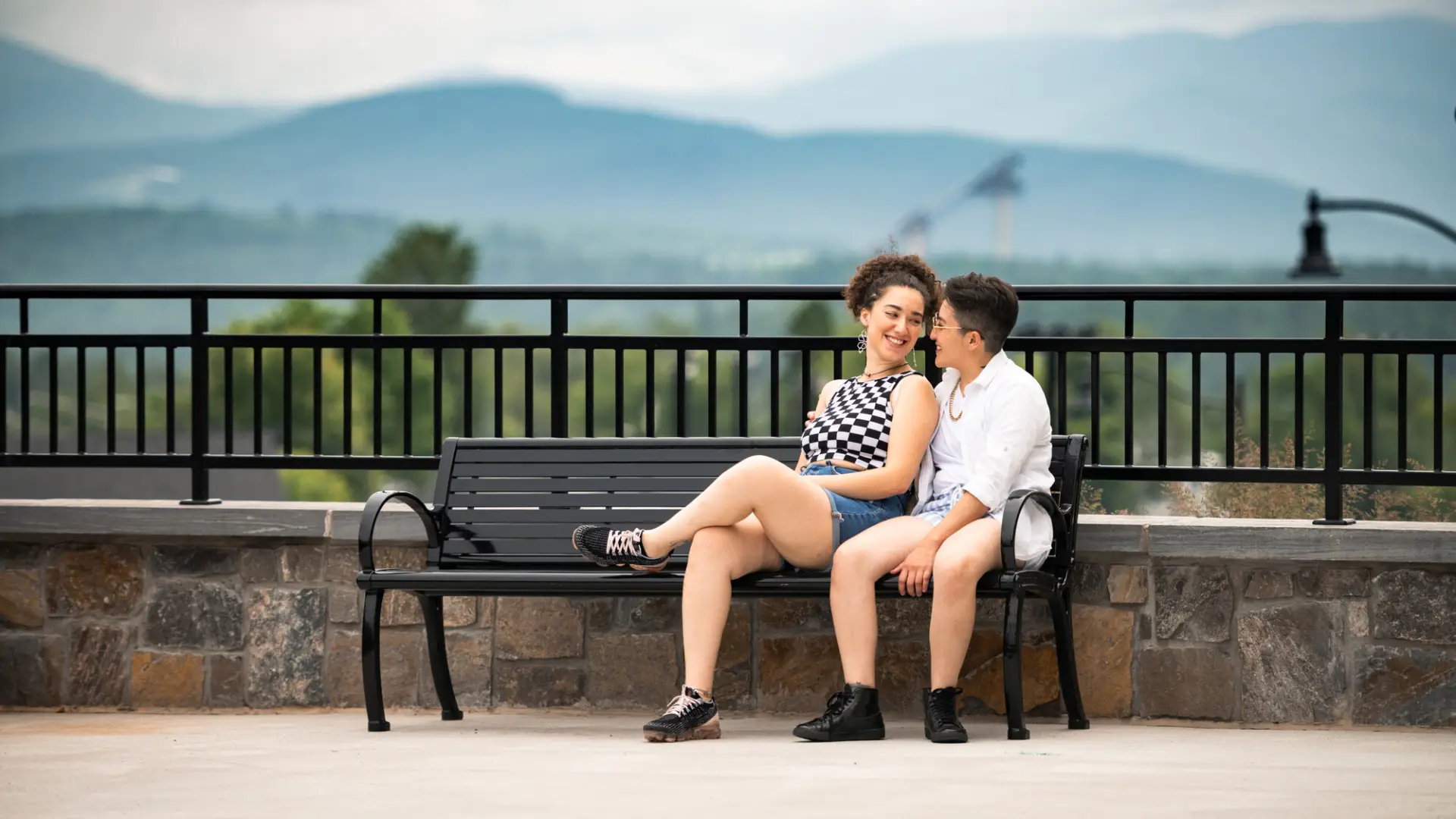 Two women sit on a park bench.