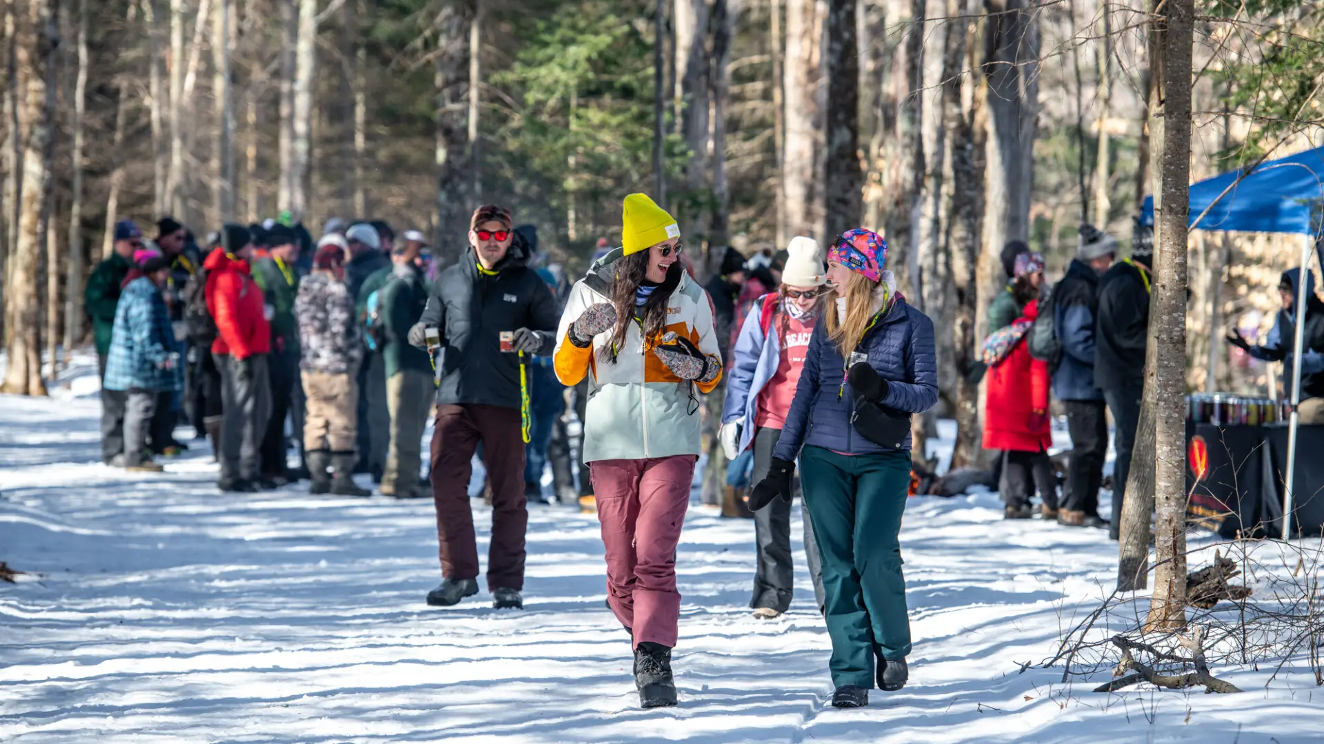 Two ladies walk down the trail with more brewski attendees behind them.