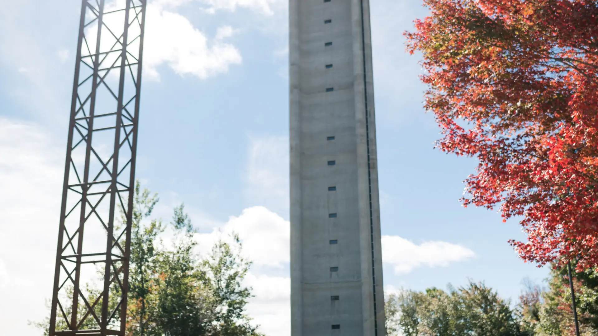 A photo of one of the ski jumps at the Olympic Jumping Complex in Lake Placid, with fall foliage in the distance