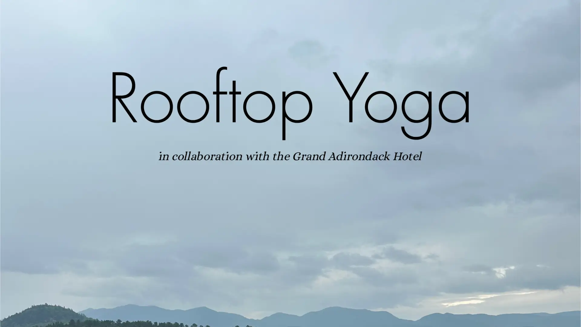 Rooftop Yoga in collaboration with the Grand Adirondack Hotel. A calm lake and mountain range are visible in the background.
