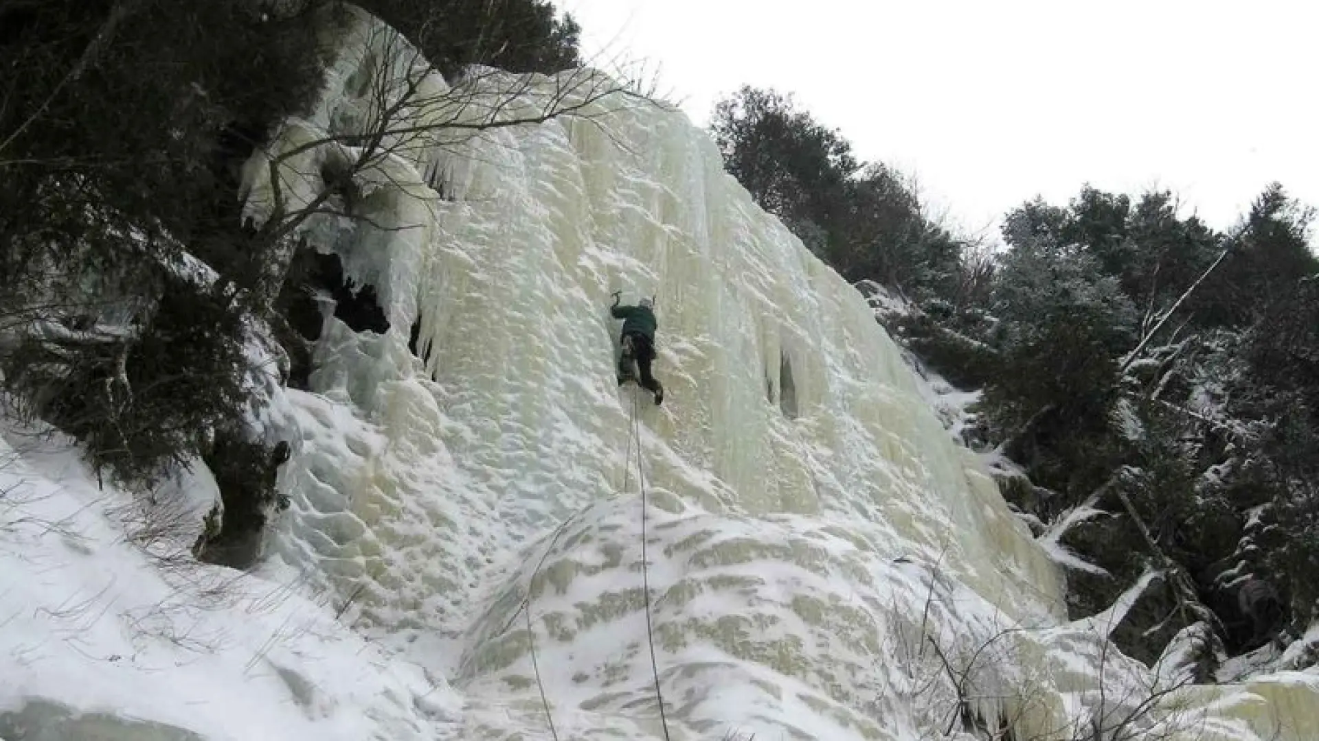 An ice climber leading up a headwall.