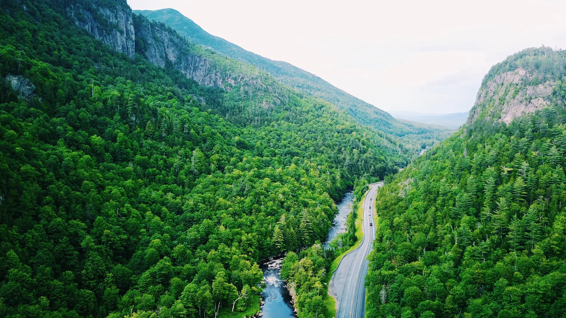 An aerial view of a road going through a narrow mountain pass.