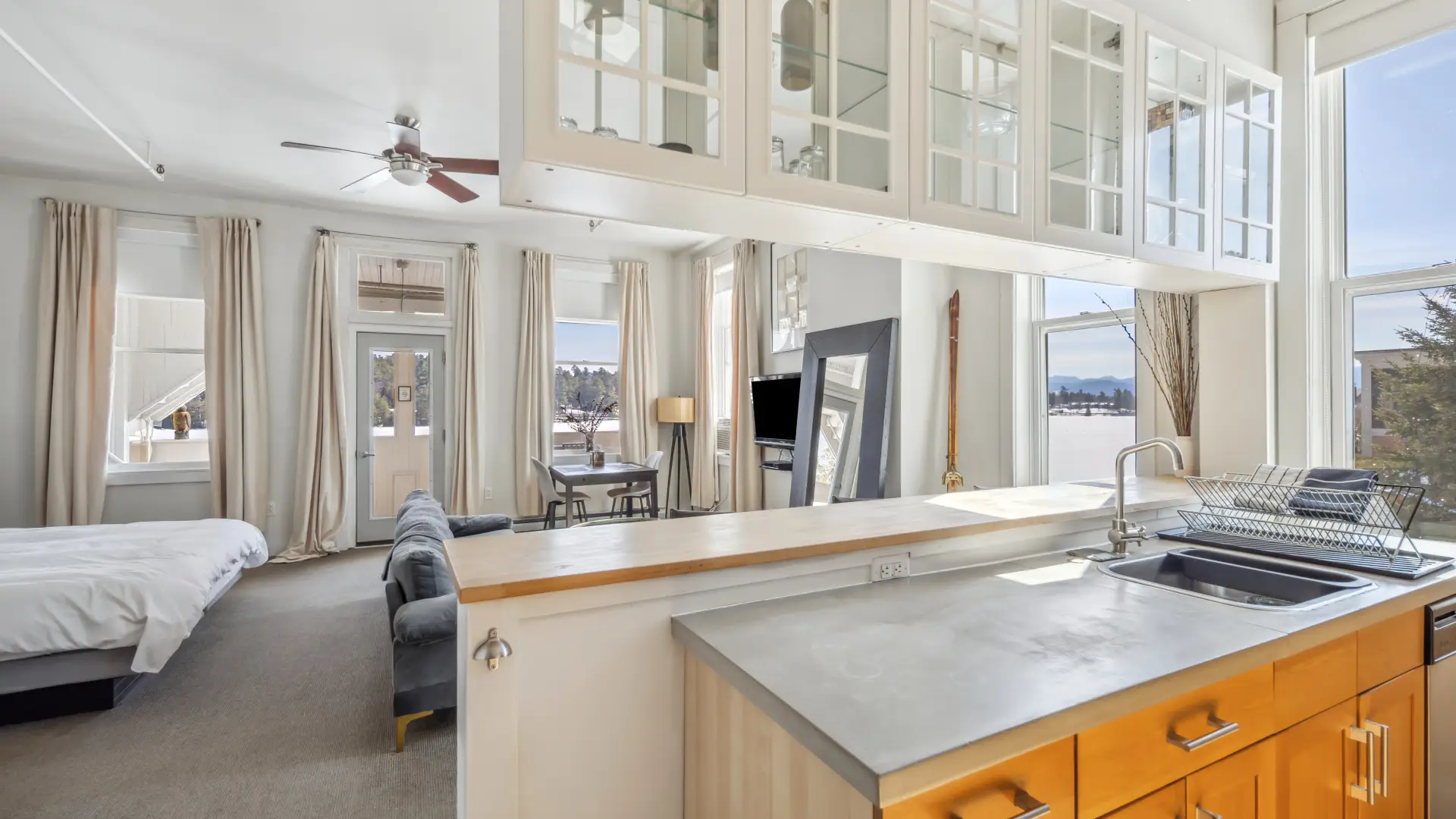 The view of the bedroom space with walls full windows overlooking Mirror Lake.