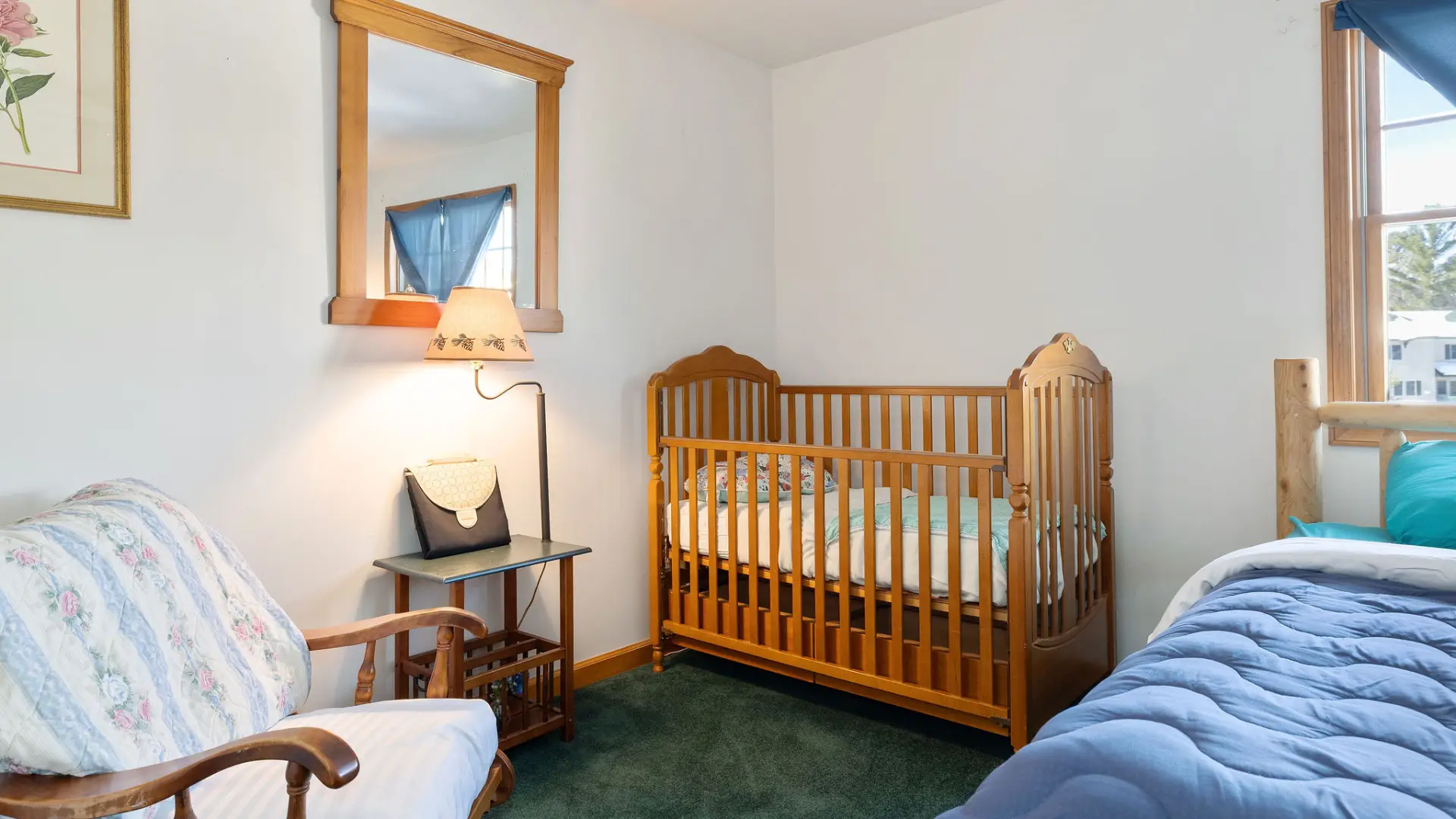 A wooden crib or toddler bed in the lower level bedroom at Lake Placid Pinehill Townhouse.
