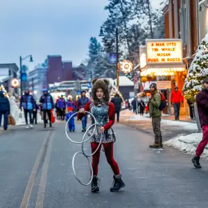 A woman dances with giant rings at a Main Street event in Lake Placid in winter. 