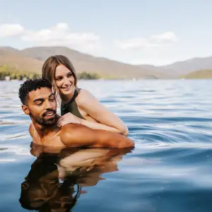A man and woman swim in a lake together. 