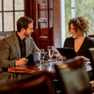 A couple sits at a table looking at menus