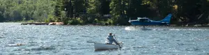 A person paddles out across a lake. 