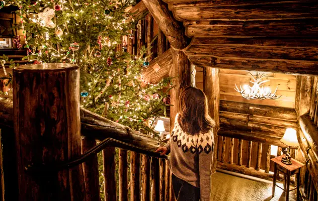 A woman walks up the stairs to a lodge during the holidays.