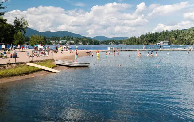 A public beach with people swimming in the summer.