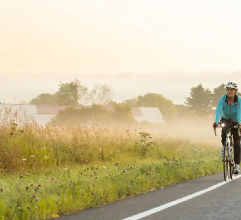 A biker rides down a secluded misty field