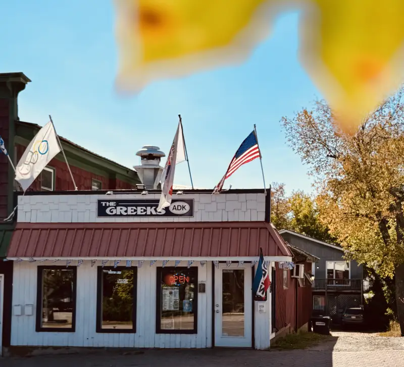 The exterior of The Greeks ADK surrounded by fall color