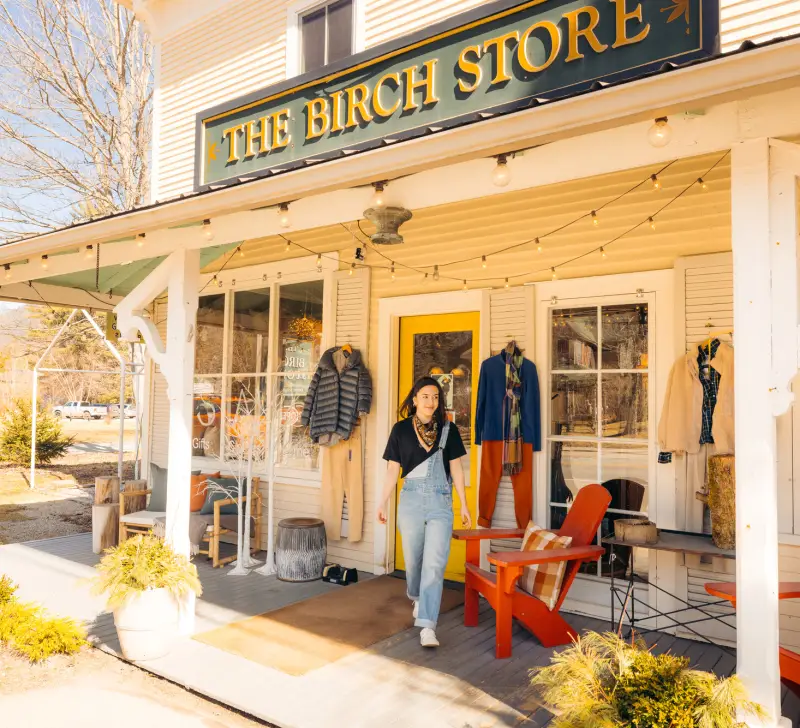 The front entry way to The Birch Store with red adirondack chairs and a large overhang