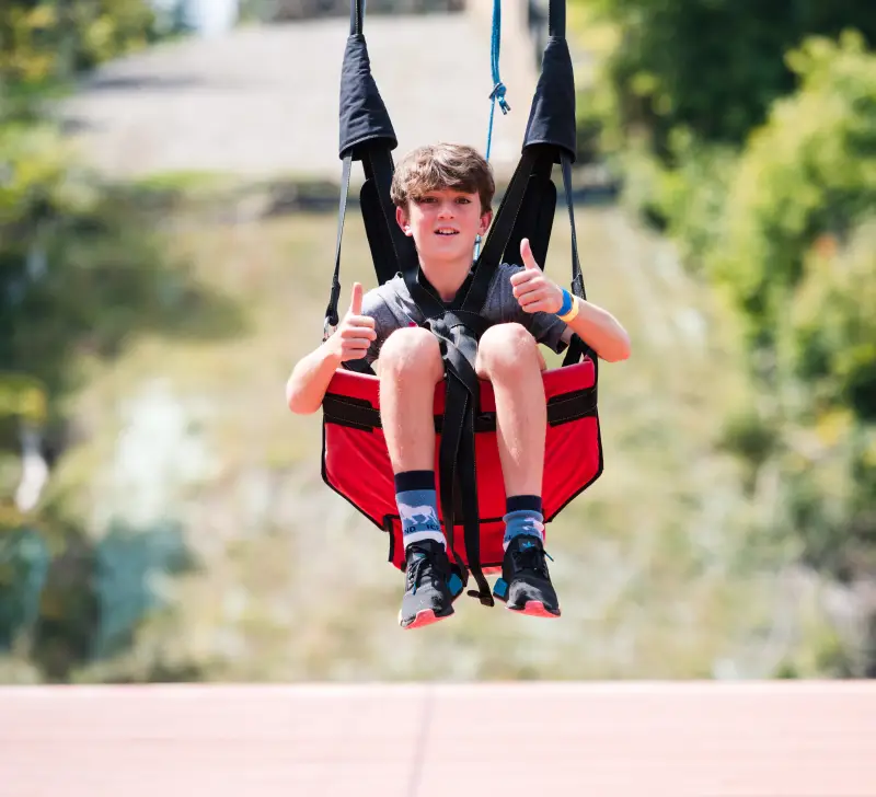 Child give thumbs up fro the zip Line