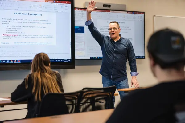 A man gives a lecture to college students.
