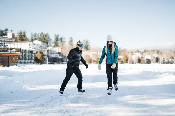 A couple ice skating outside in Lake Placid.