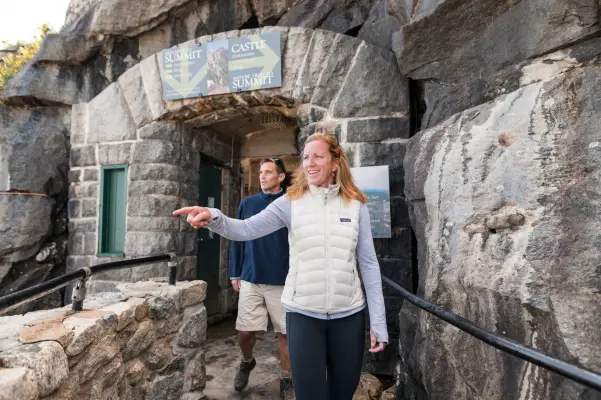 A woman and man explore an old stone lookout. 