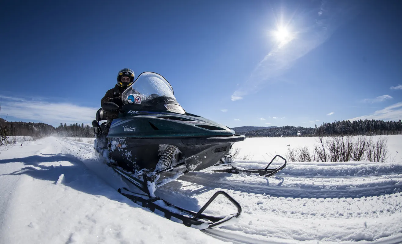 A person snowmobiling on the Adirondack Rail Trail.