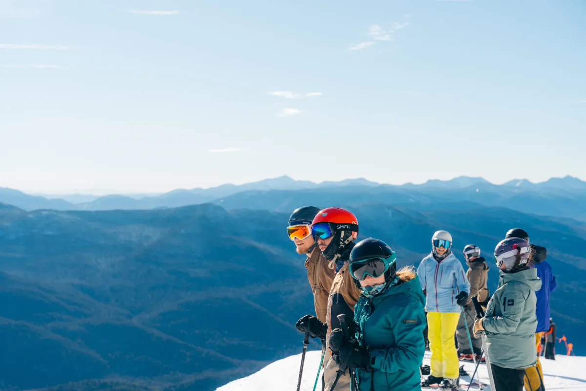 A group looks out to a landscape of mountains. 