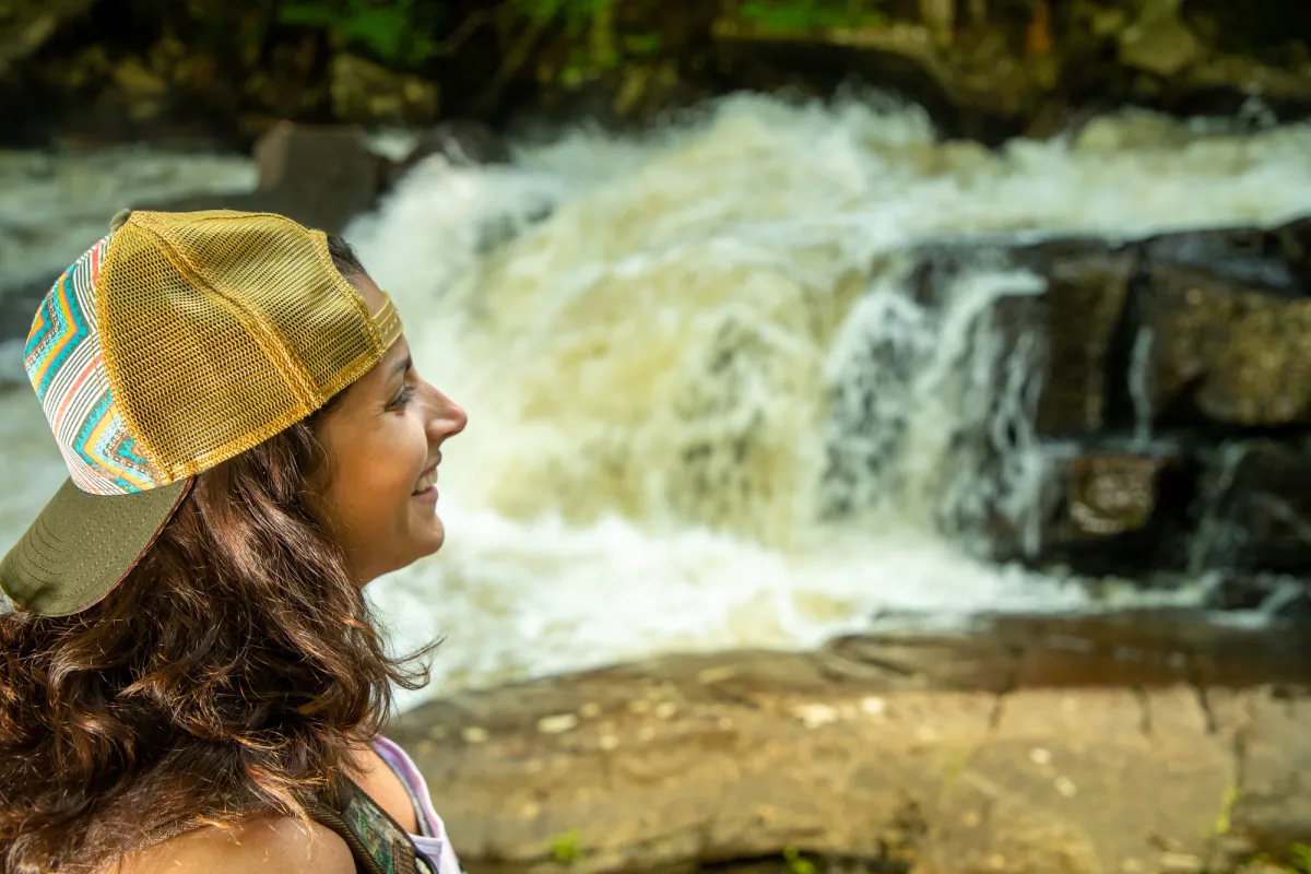 A woman looks at a waterfall.