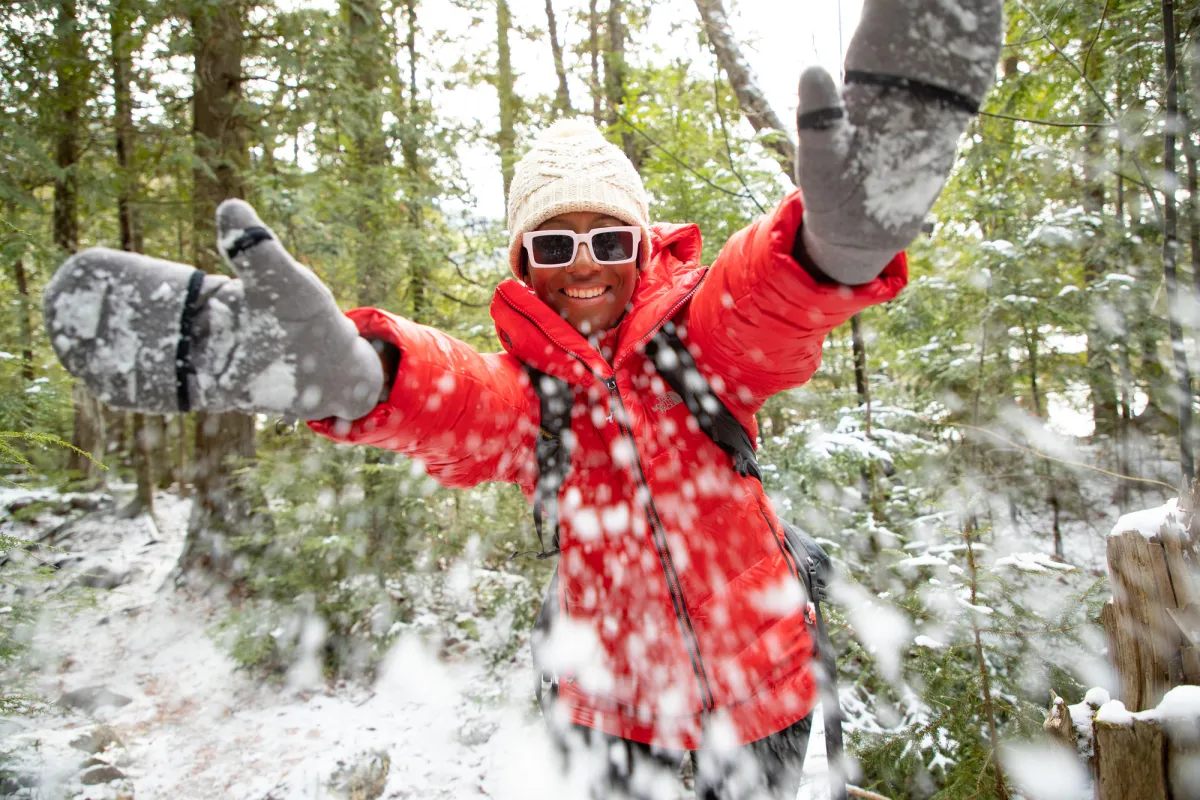 A winter hiker throwing snow.