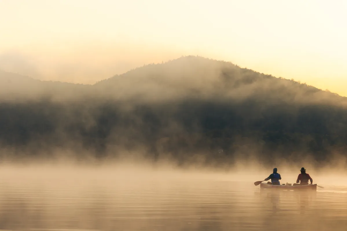 Paddlers in the lake's mist.