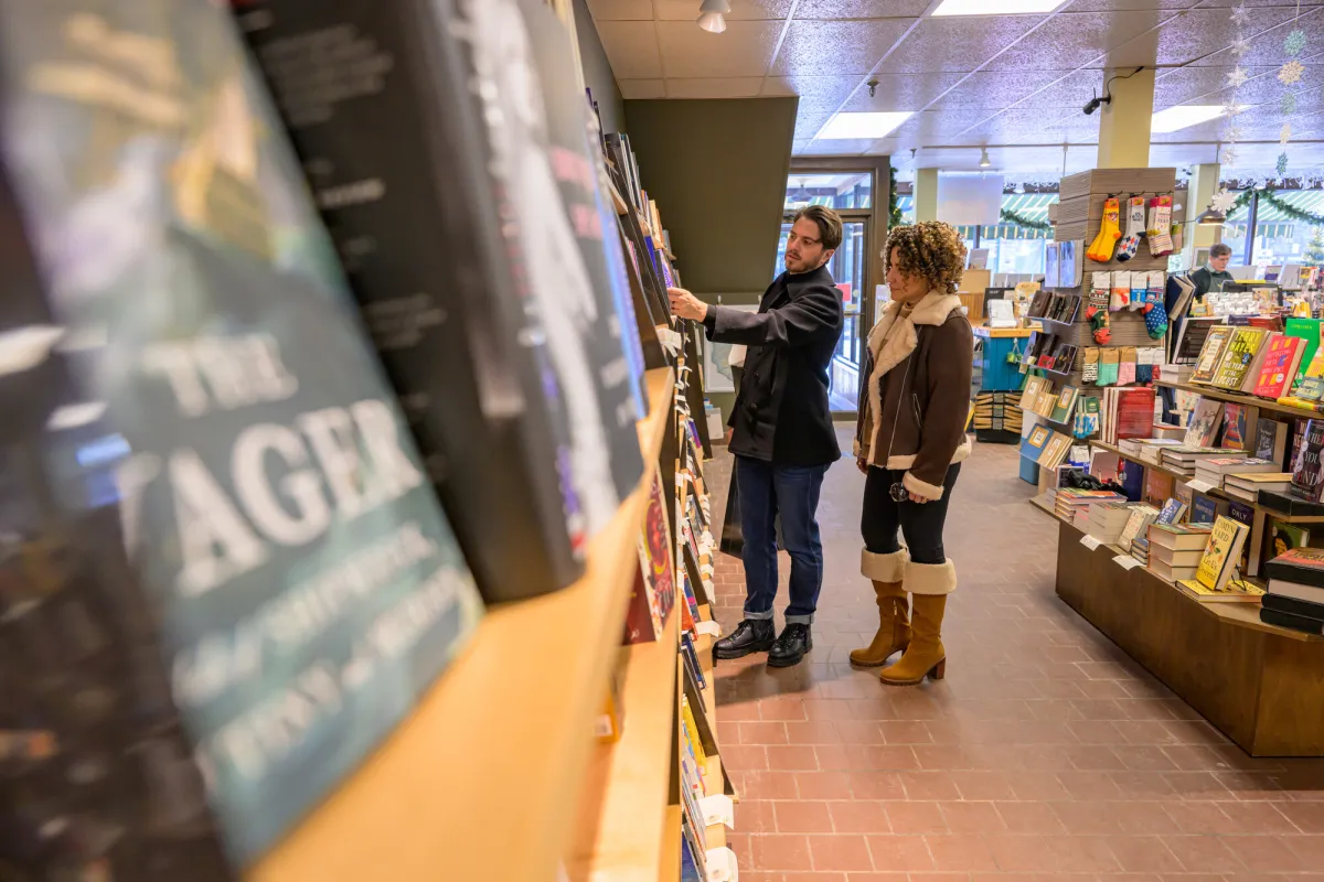A man and a woman browse at a bookstore