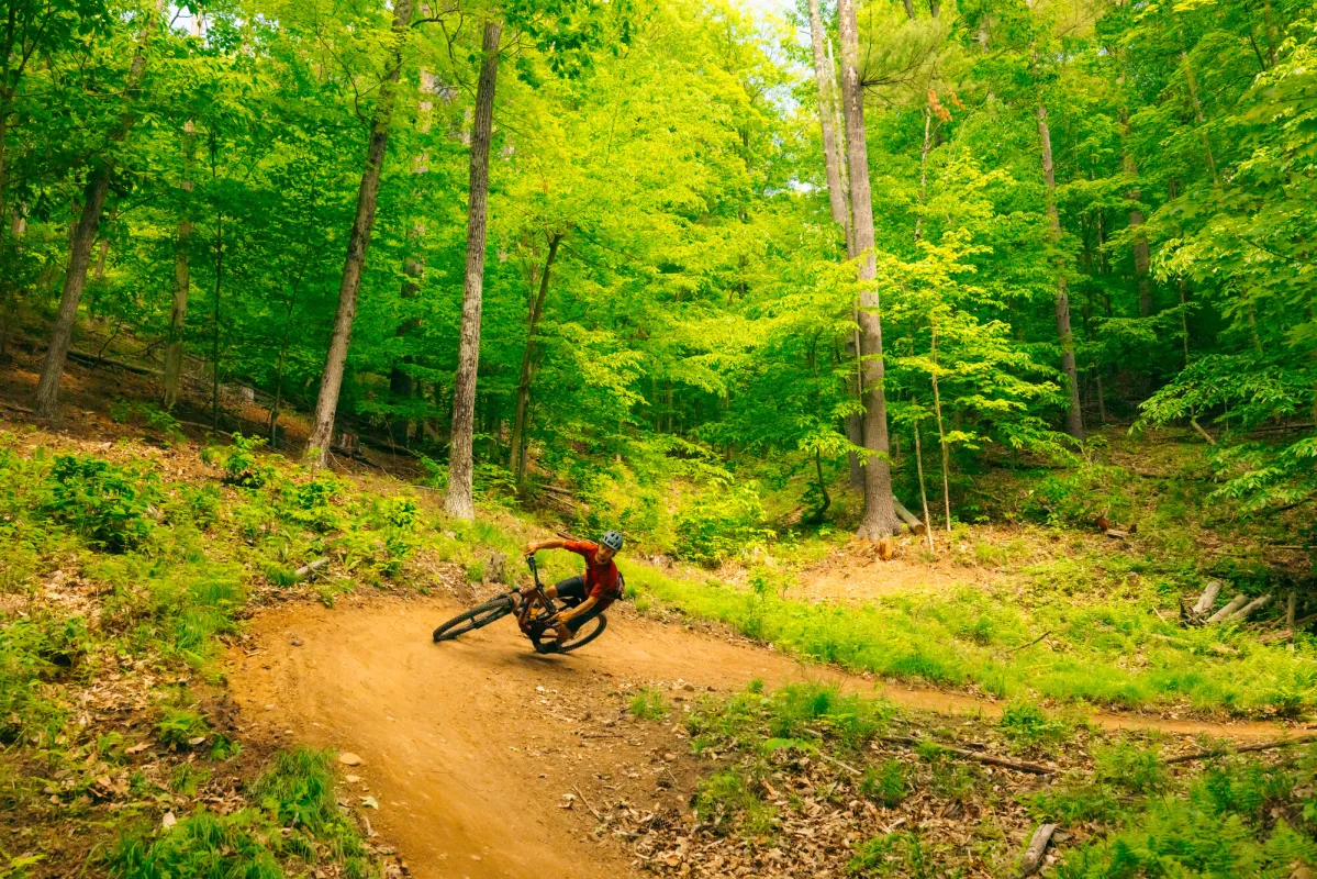 A mountain biker carving around a berm.