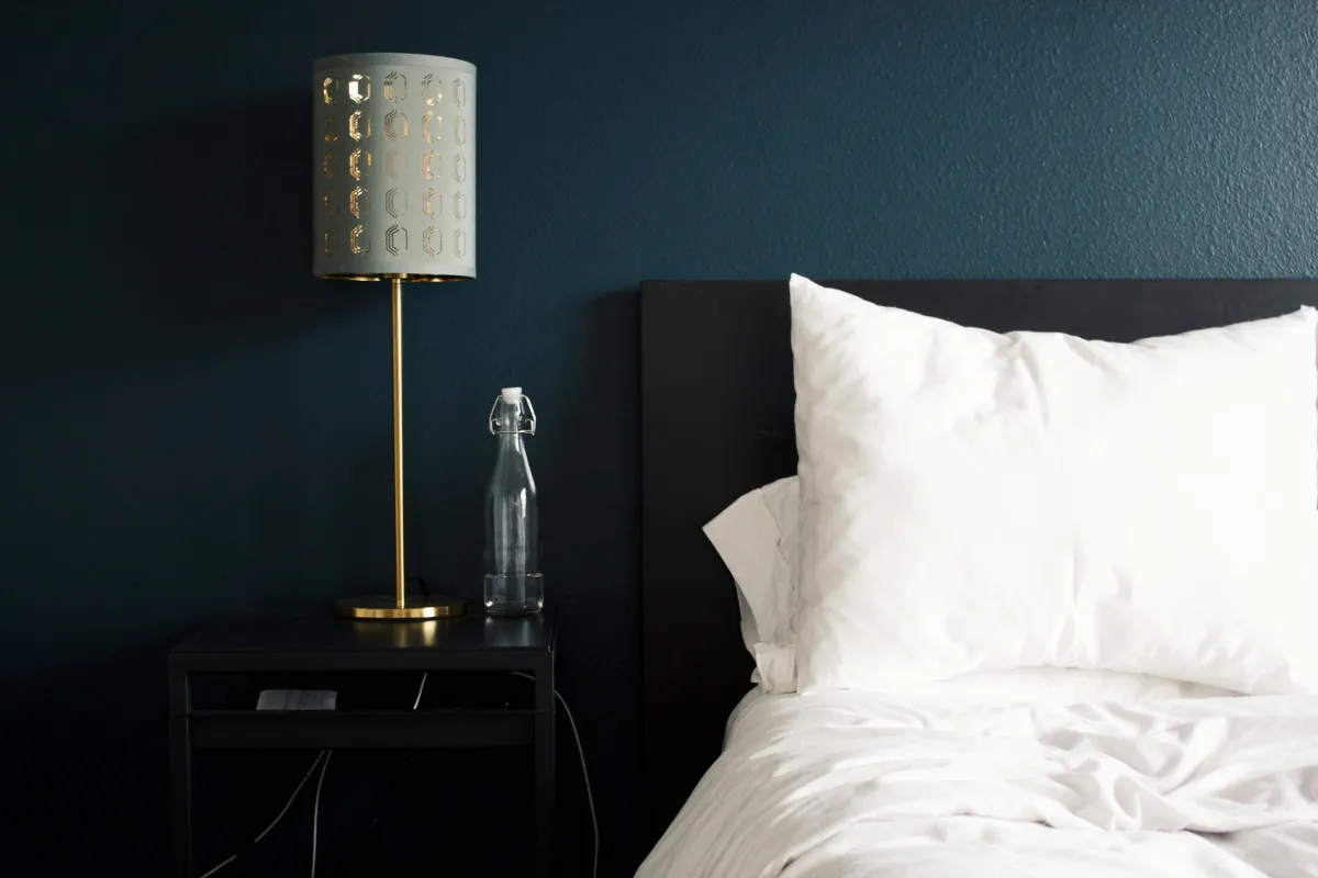 A bedside with a blue wall. 