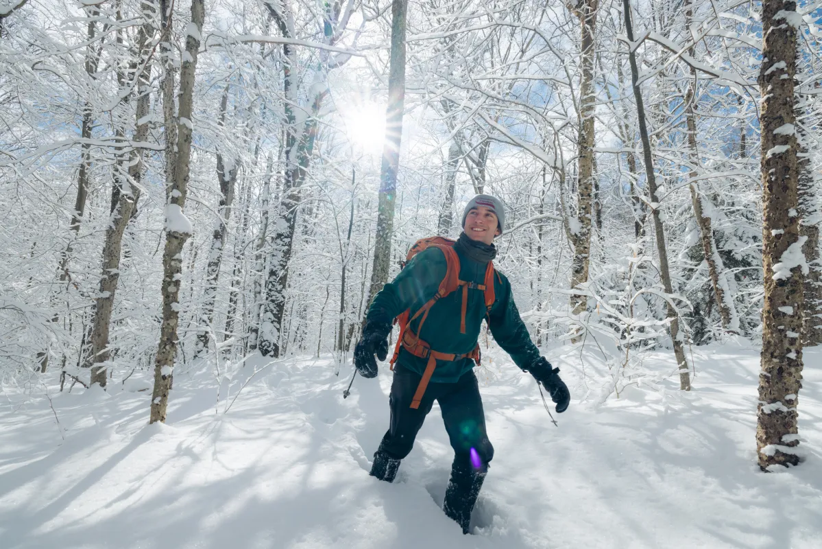 A winter hiker walking through the woods