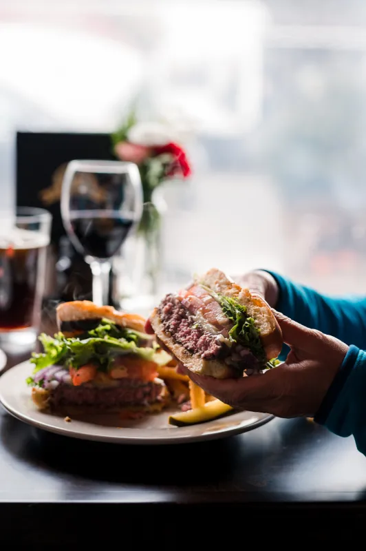 A woman eats a burger on a winter day. 