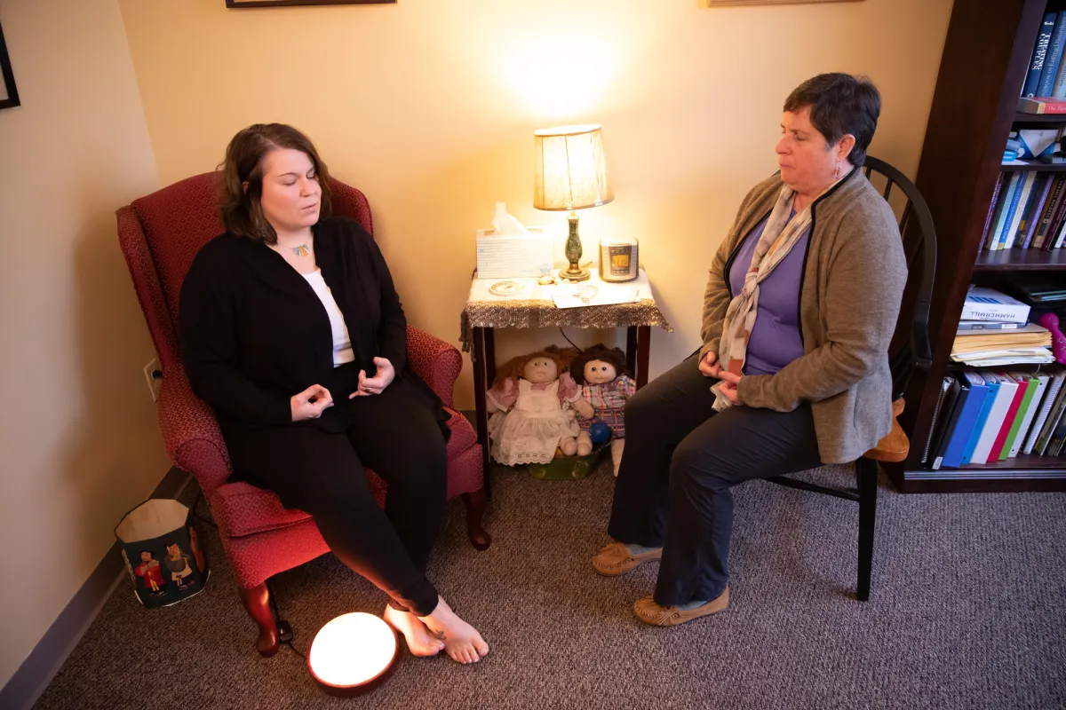 Two women sit and talk during a therapy session. 