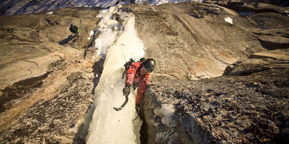 An ice climber on a pillar of ice.