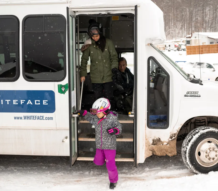 A family getting off of a shuttle bus