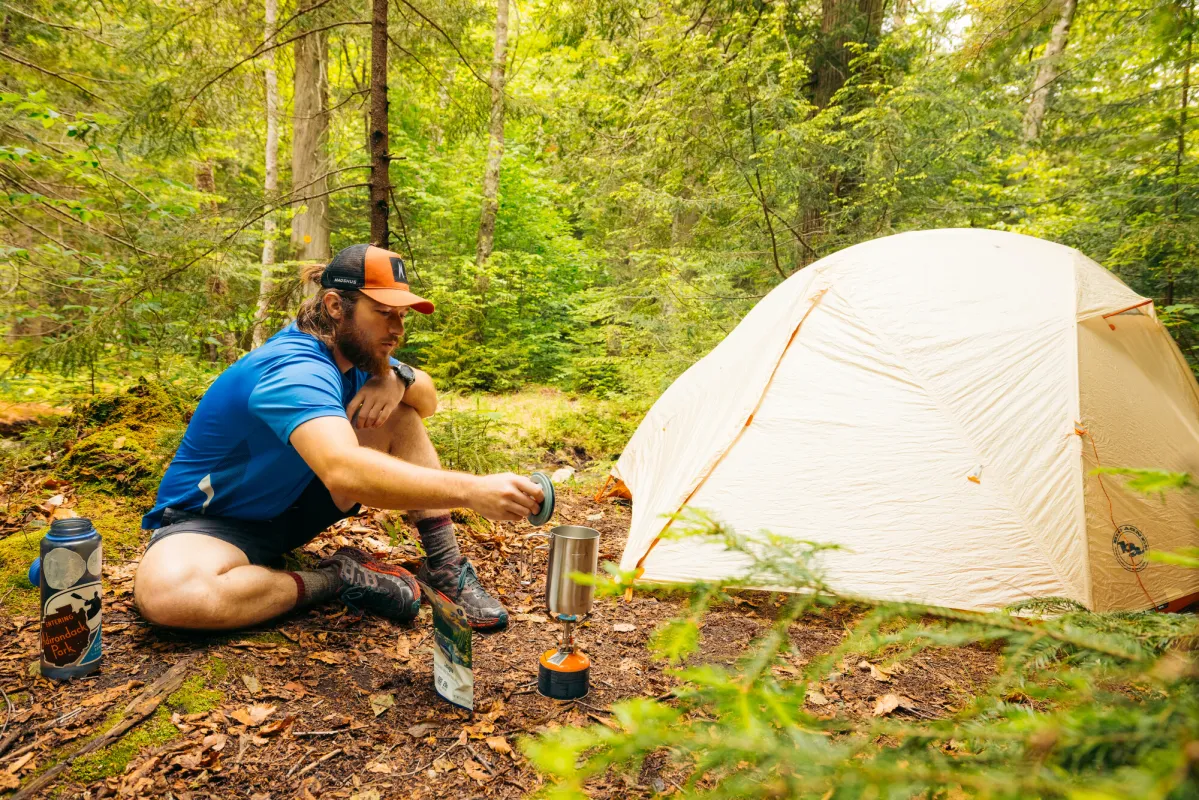 A camper making food by his tent