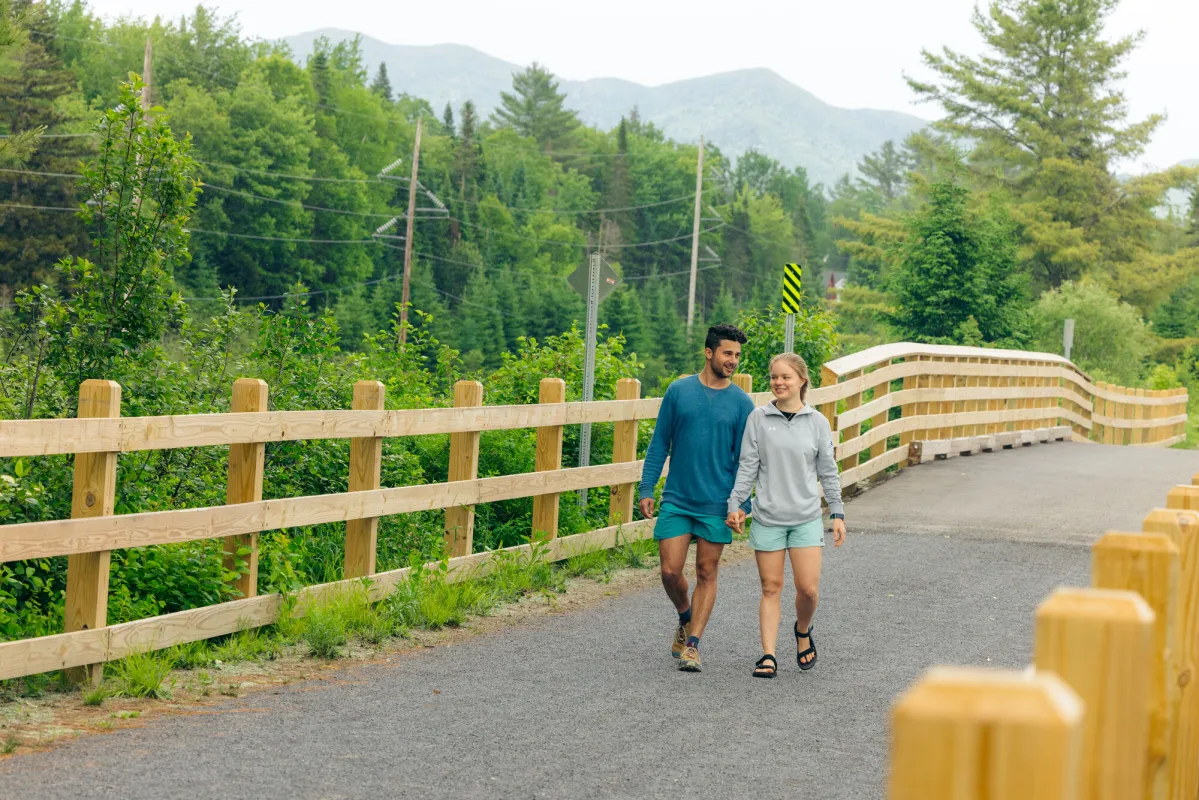 Two people walking on a rail trail.