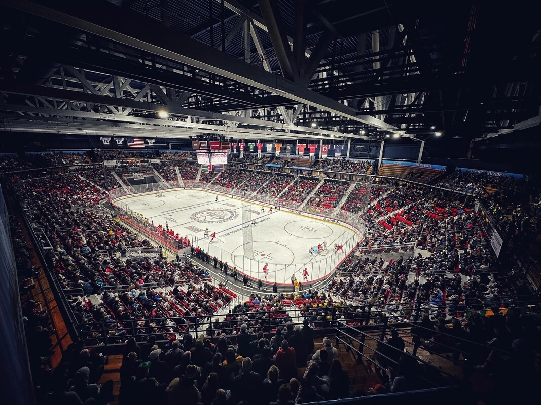 Packed 1980 Herb Brooks Arena with lights illuminating the ice rink