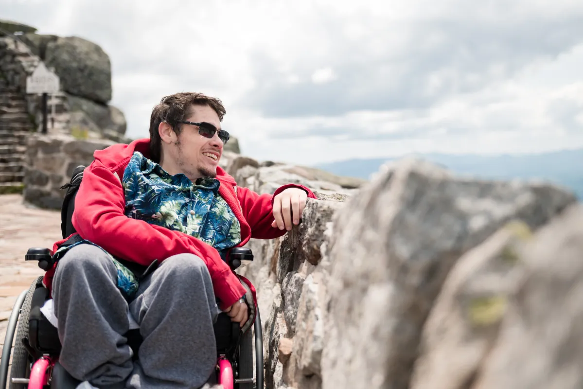 A man in a wheelchair looks over a stone walkway. 