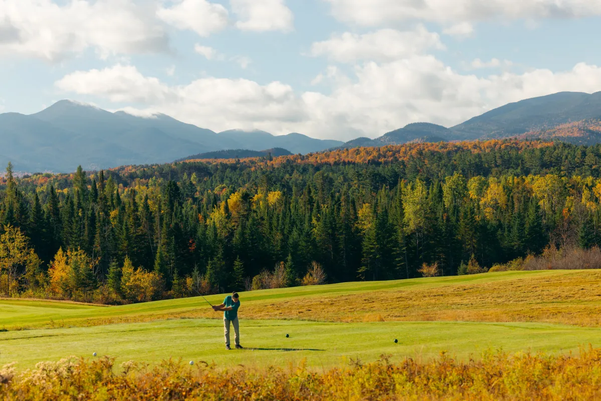 A golfer on the greens in the fall.
