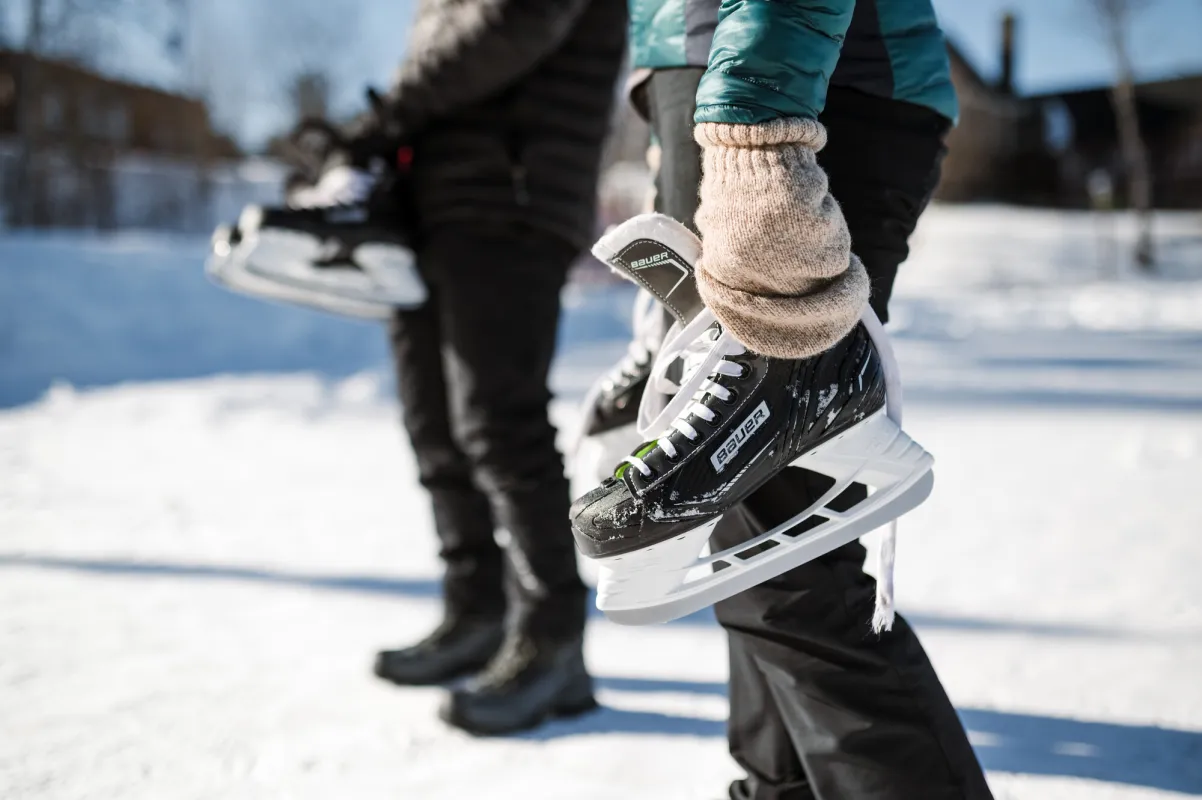 A man and woman hold ice skates.