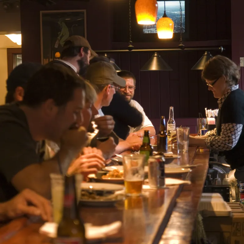A group of people drinking and eating at a bar in Lake Placid