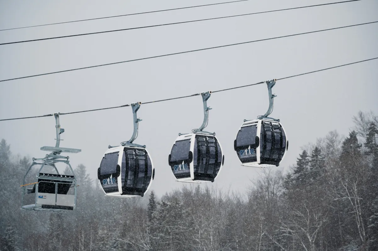 Three gondolas glide through the air. 
