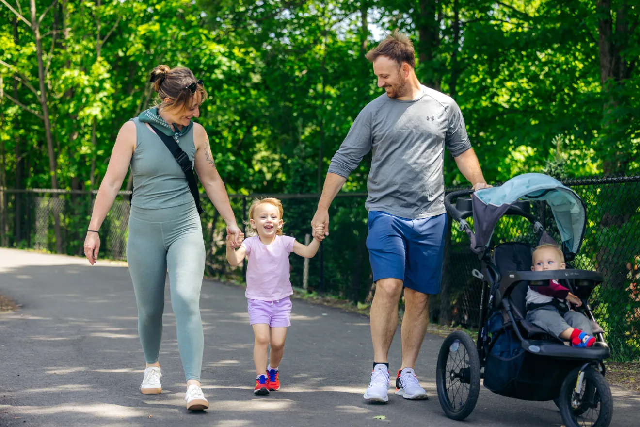 A man and woman walk their two kids on a path. 